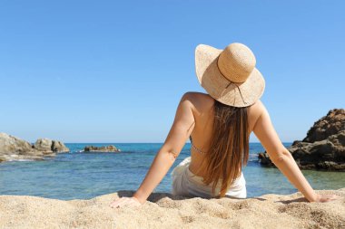 Tatile sahilde oturmuş rahatlatıcı sunbather