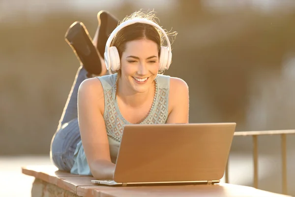 Boldog asszony néz média laptop fejhallgató — Stock Fotó