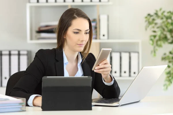 Femme d'affaires occupée utilisant plusieurs appareils au bureau — Photo