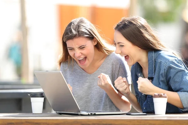 Ενθουσιασμένοι οι γυναίκες τον έλεγχο περιεχομένου του φορητού υπολογιστή σε ένα πάρκο — Φωτογραφία Αρχείου
