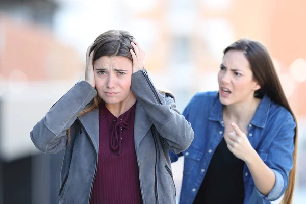 Meisje schelden haar triest vriend die naar de camera kijkt — Stockfoto