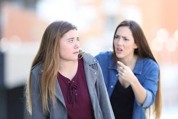 Злая девушка ругает своего смущенного друга на улице — стоковое фото