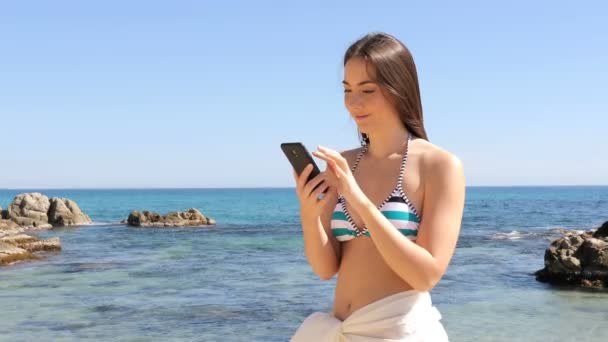 Donna Sorpresa Bikini Che Legge Contenuti Smartphone Spiaggia Durante Vacanze — Video Stock