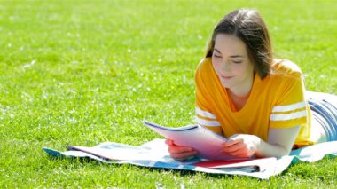 Öğrenci öğrenme notlar bir güneşli gün çim üzerinde yalan