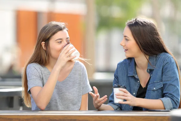공원에서 커피를 마시며 이야기 하 고 마시는 두 명의 캐주얼 한 친구 들 — 스톡 사진