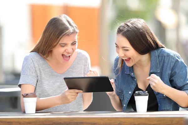 Teman-teman yang bersemangat menonton konten tablet di taman — Stok Foto