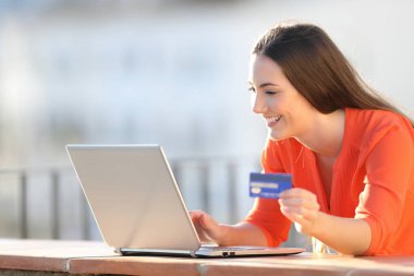 Dizüstü bilgisayar ve kart ile online satın mutlu kadın