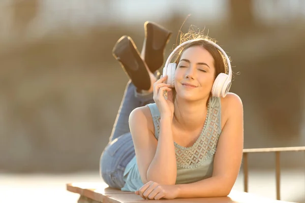 Vrouw genieten van het luisteren naar muziek in een balkon — Stockfoto