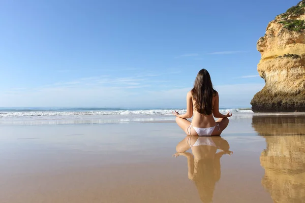 Woman practicing yoga exercises on a solitary beach — Stock Photo, Image