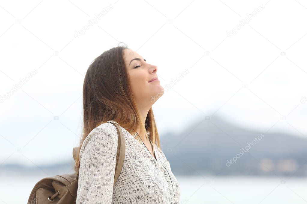 Happy woman on the beach breathing fresh air