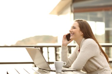Guest talking on phone in an apartment terrace