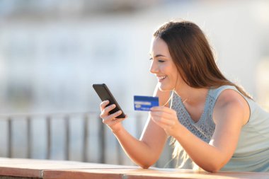 Mutlu kız kredi kartı ve telefon ile ödeme yapıyor