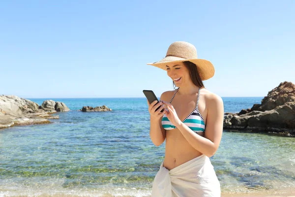 Feliz turista navegando por el teléfono inteligente en la playa — Foto de Stock