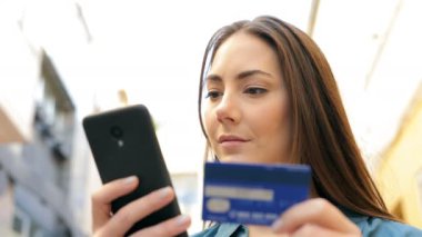 Ciddi kadın sokakta akıllı telefon kredi kartı ile ödeme