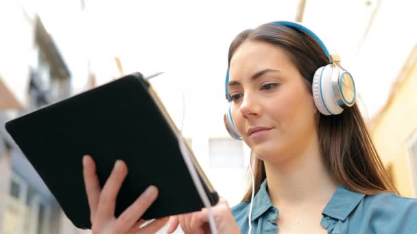 Mujer Seria Usando Una Tableta Auriculares Para Navegar Por Contenido — Vídeo de stock