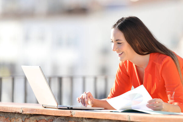 Happy entrepreneur working with laptop and charts