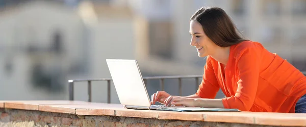 Entreprenör som arbetar med en bärbar dator i en balkong — Stockfoto