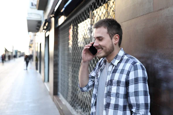 Hombre feliz hablando por teléfono inteligente en una calle del casco antiguo — Foto de Stock