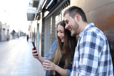 Heyecanlı arkadaşlar sokakta şaşırtıcı telefon içeriği bulma