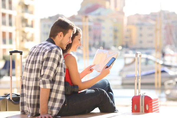 A turisták ellenőrzése Térkép és okos telefon nyaralni — Stock Fotó