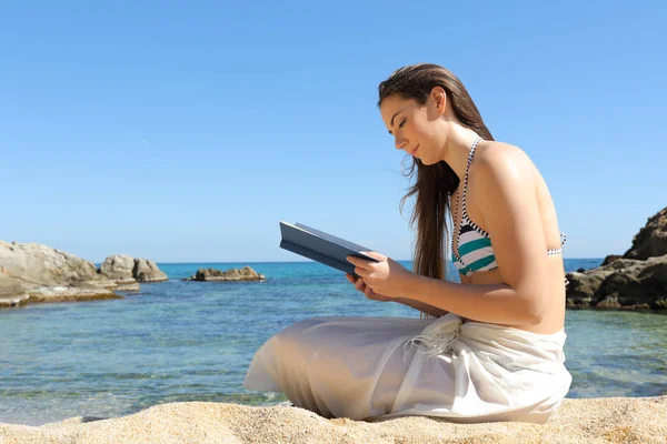 Vrouw die een boek leest over zomervakantie op het strand — Stockfoto
