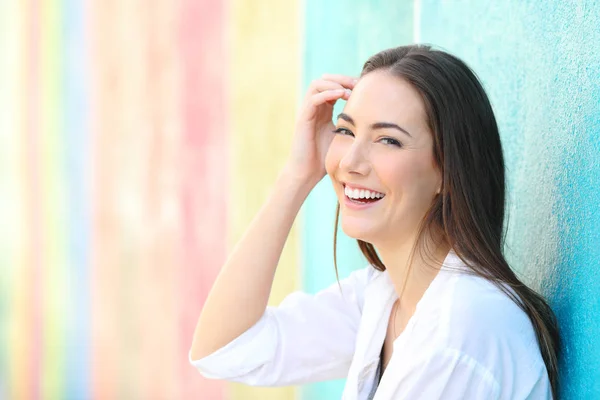 Schoonheid gelukkige vrouw in een kleurrijke muur kijken naar camera — Stockfoto