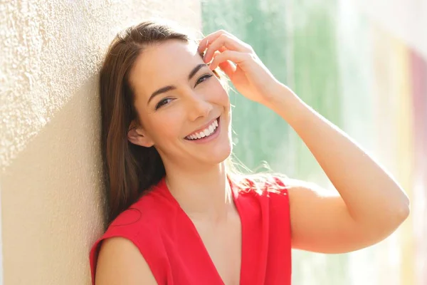 Uppriktig kvinna i rött med perfekt leende tittar på kamera — Stockfoto