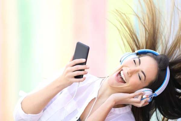 Šťastné dívčí tance poslech hudby přidržovat telefon — Stock fotografie