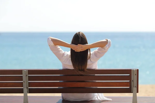 Glückliche Frau entspannt beim Betrachten des Ozeans am Strand — Stockfoto