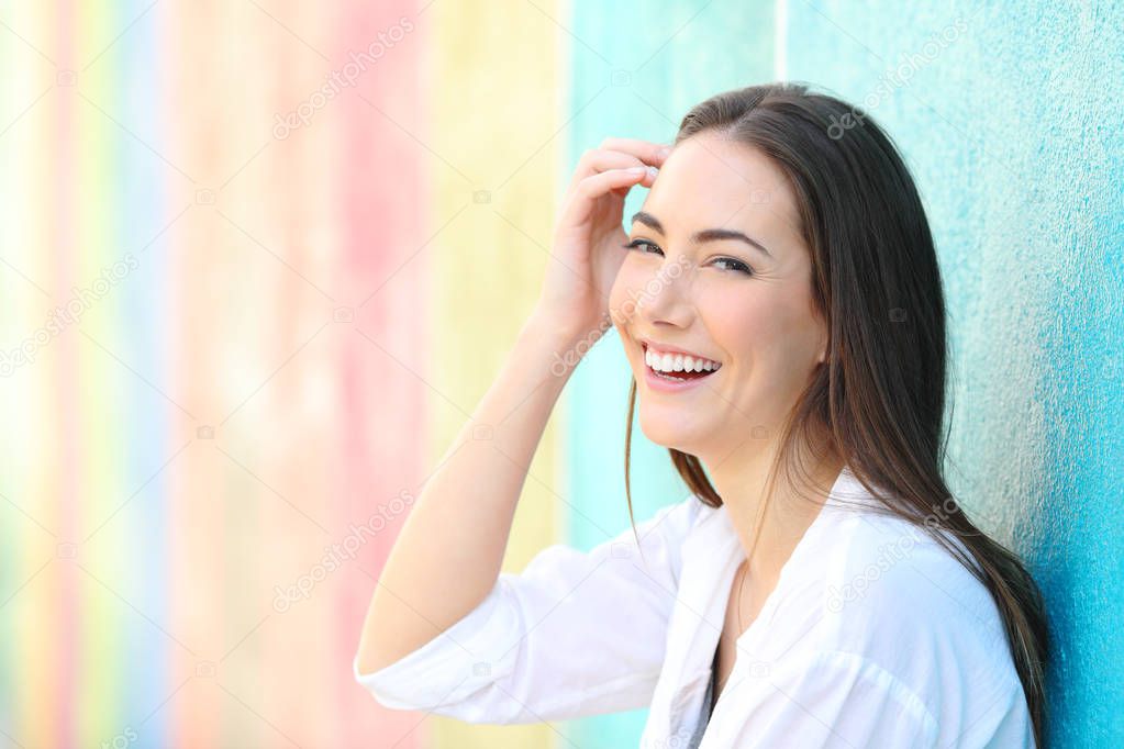 Beauty happy woman in a colorful wall looking at camera