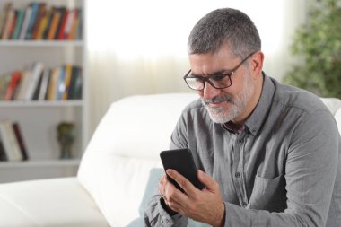 Evde akıllı telefon kullanan yetişkin adam