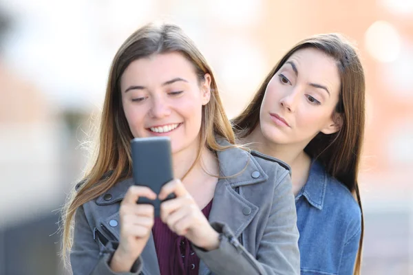 Gossip woman spying the phone of a friend — Stock Photo, Image