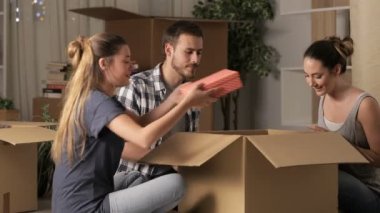 Üç mutlu oda arkadaşı gece eşyalarını unboxing eve hareket