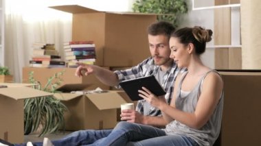 Mutlu çift katta oturan reformları planlamak için bir tablet kullanarak eve hareket