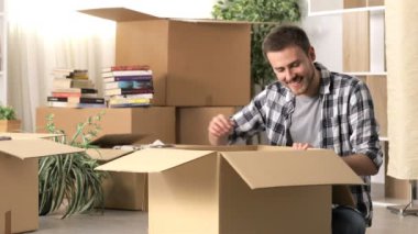 Mutlu adam yerde oturan eşyalarını unboxing eve hareket