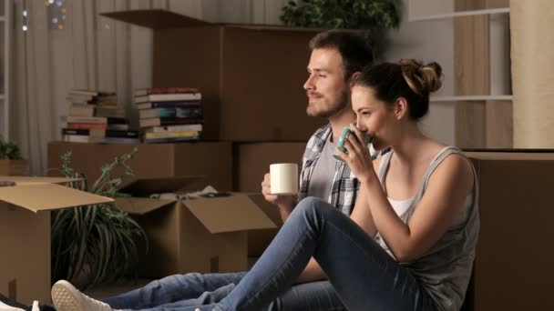 Koppel Verhuizen Thuis Rusten Drinken Koffie Zittend Vloer Thuis — Stockvideo