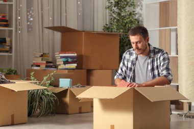Ciddi adam gece eşyalarını unboxing eve hareket