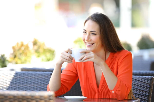 Счастливая женщина отдыхает, пьет кофе на террасе бара — стоковое фото
