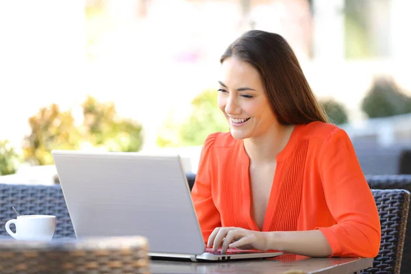 Mutlu kadın bir kafede bir dizüstü bilgisayar kullanıyor — Stok fotoğraf