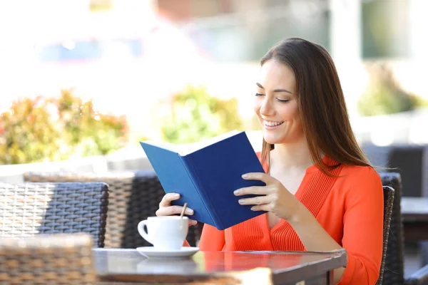 Mulher feliz lendo um livro em um café — Fotografia de Stock