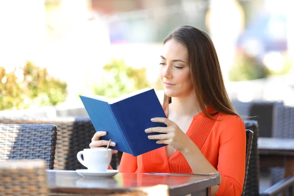 Eine ernsthafte Frau liest in einem Café ein Buch — Stockfoto