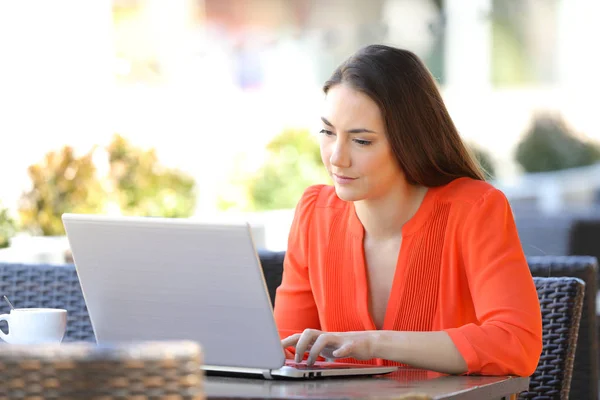 Serieuze vrouw is met behulp van een laptop in een coffeeshop — Stockfoto