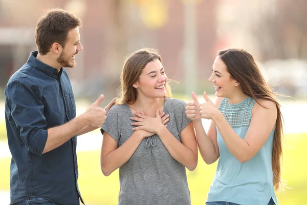 Amigos felicitando a una chica feliz en la calle —  Fotos de Stock