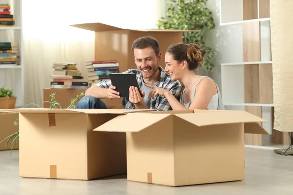 Casal movendo para casa verificando o conteúdo do tablet — Fotografia de Stock