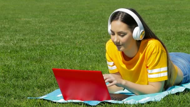 少女有一个视频通话与笔记本电脑在草地上 — 图库视频影像