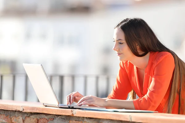 Entrepreneur memasukkan data pada laptop di balkon — Stok Foto