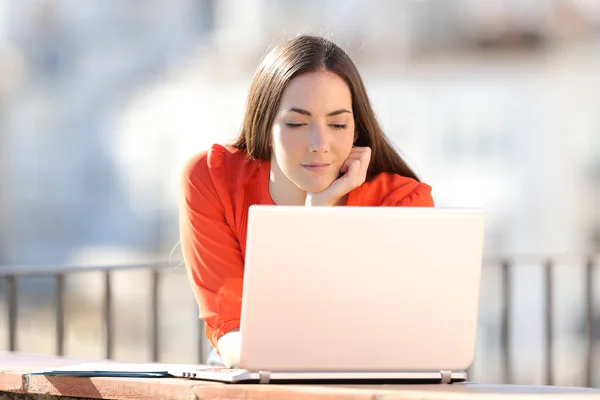 Entreprenör tittar på online laptop innehåll i en balkong — Stockfoto