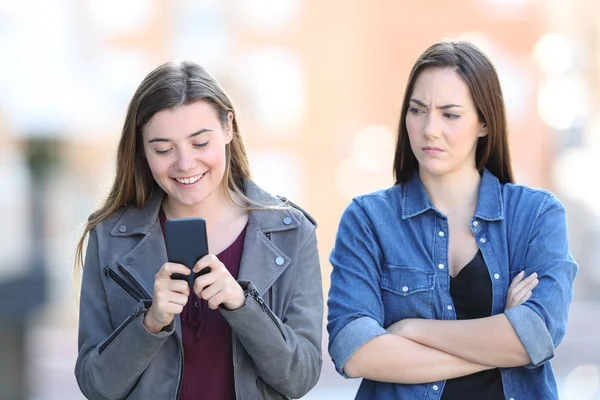 愤怒的女人与她的朋友谁正在使用电话 — 图库照片