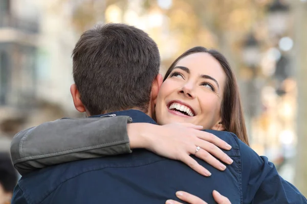 Щаслива дівчина обіймає свого хлопця на міській вулиці — стокове фото