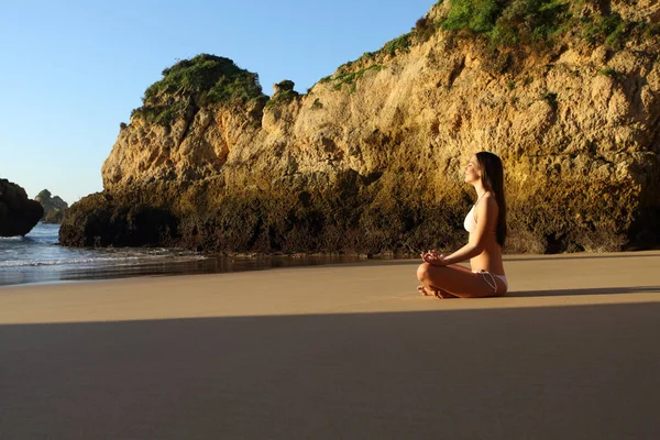 Profiel van een vrouw die yoga beoefenen op het strand — Stockfoto